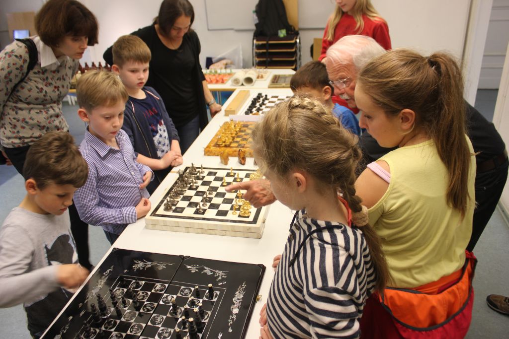 Kinder betrachten historische Schachfiguren